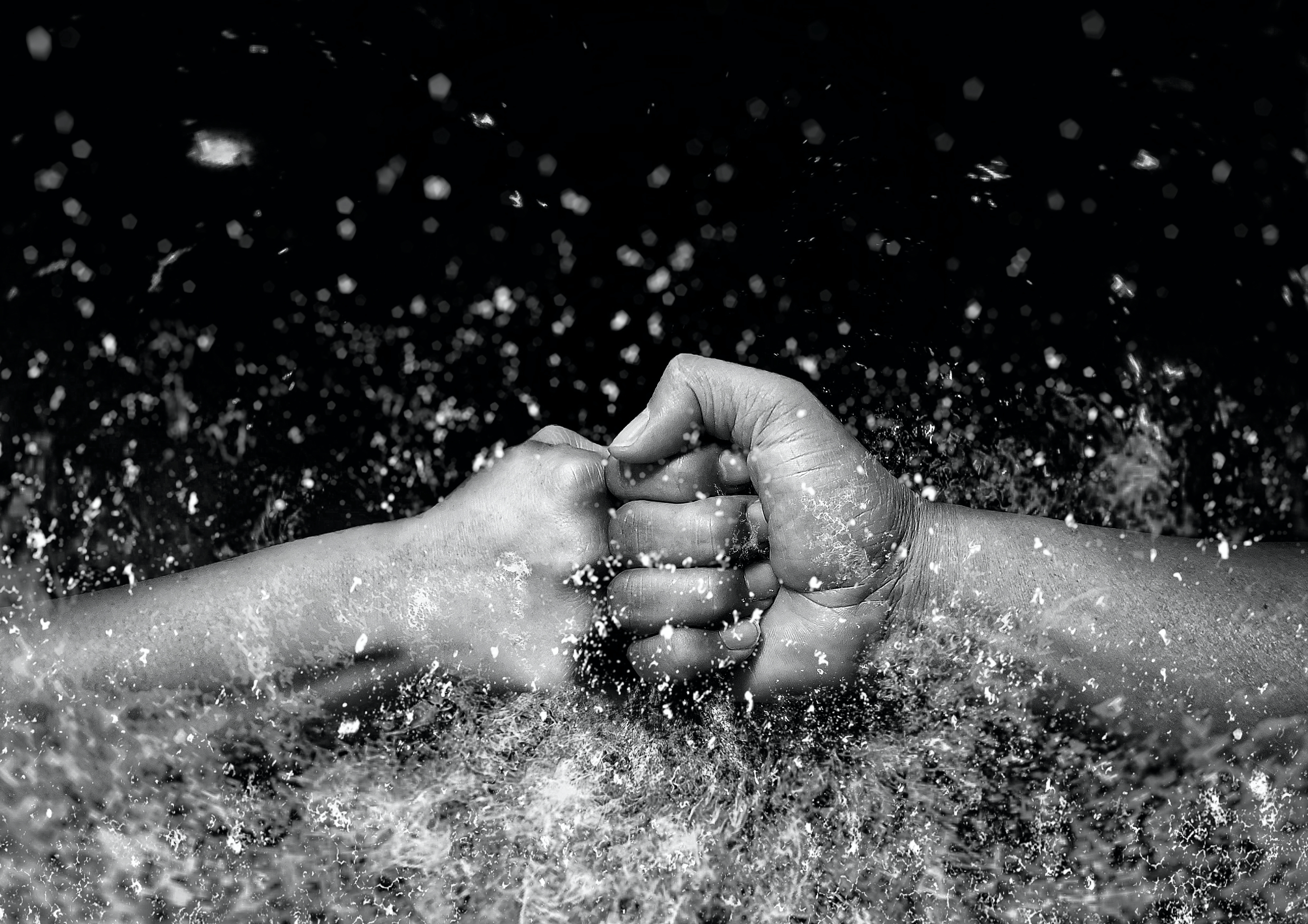 激しい火花や衝撃が走る中で、左右から力強くぶつかり合う二つの拳。情熱、挑戦、または協力して困難に立ち向かう決意を表現した画像。