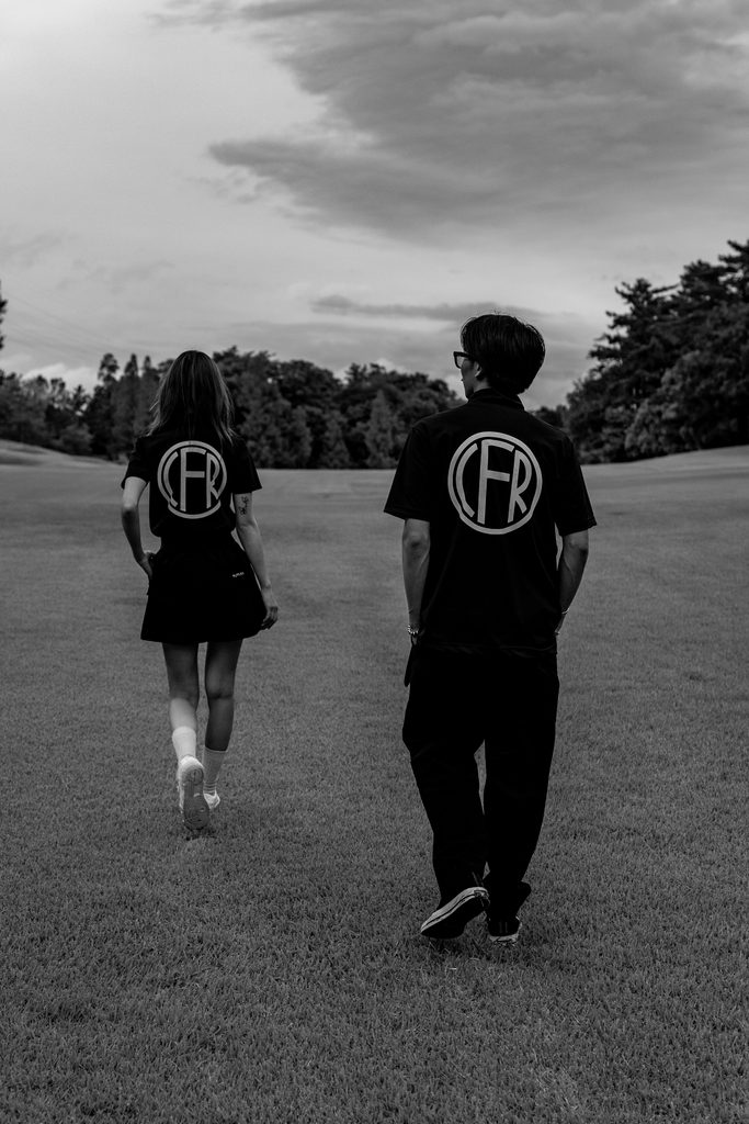 ゴルフ場のフェアウェイを歩くCIFRAゴルフウェア着用モデル2名の後ろ姿