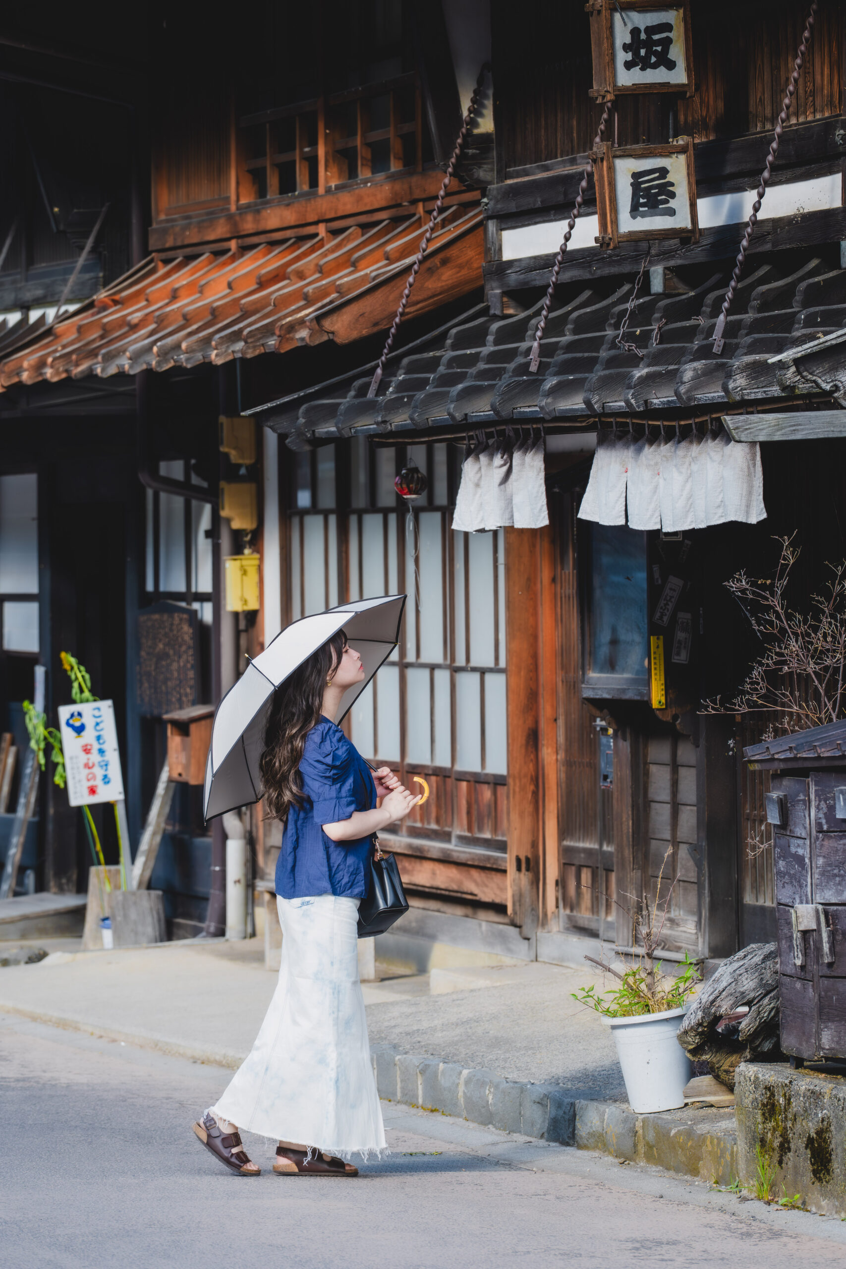 奈良井宿の歴史ある木造建築を見上げる女性を撮影した街歩きポートレート